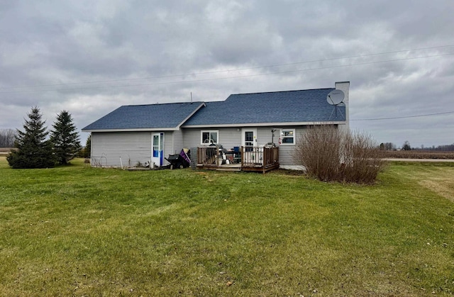 back of property with a lawn and a deck