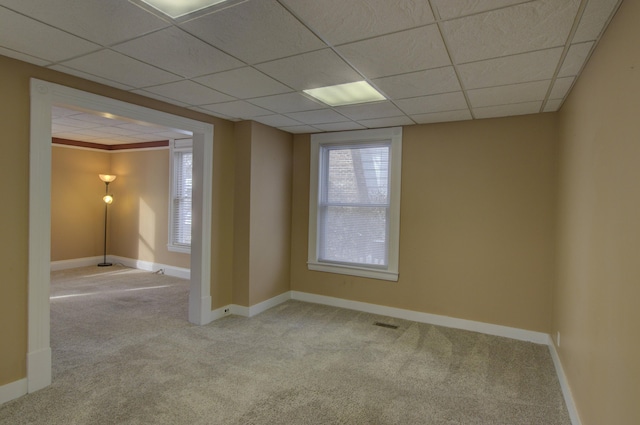 empty room with a drop ceiling and light carpet