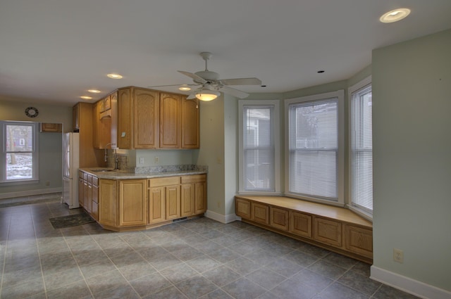 kitchen featuring ceiling fan, white fridge, a healthy amount of sunlight, and light tile patterned floors