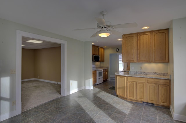 kitchen featuring white range with electric cooktop, ceiling fan, and dark carpet