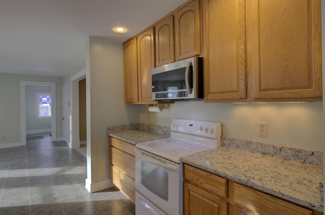 kitchen featuring tile patterned flooring, white electric range oven, and light stone countertops