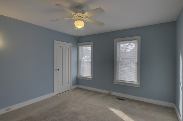 carpeted spare room with ceiling fan