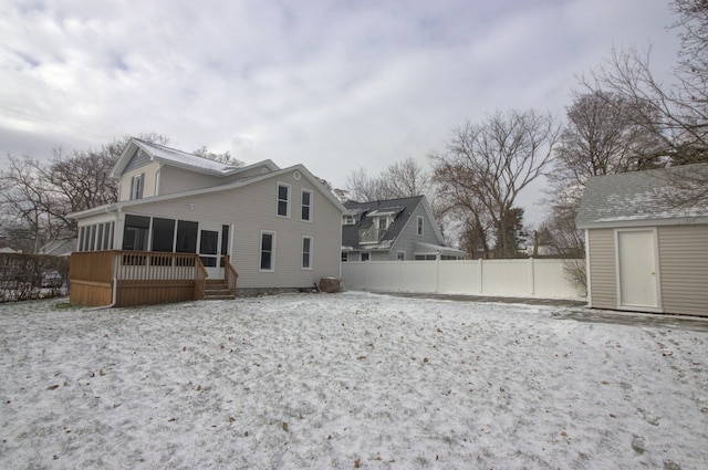 rear view of property featuring a sunroom and a shed