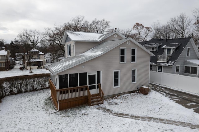 snow covered property with a sunroom