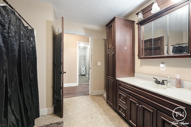 bathroom featuring hardwood / wood-style floors, vanity, and a textured ceiling