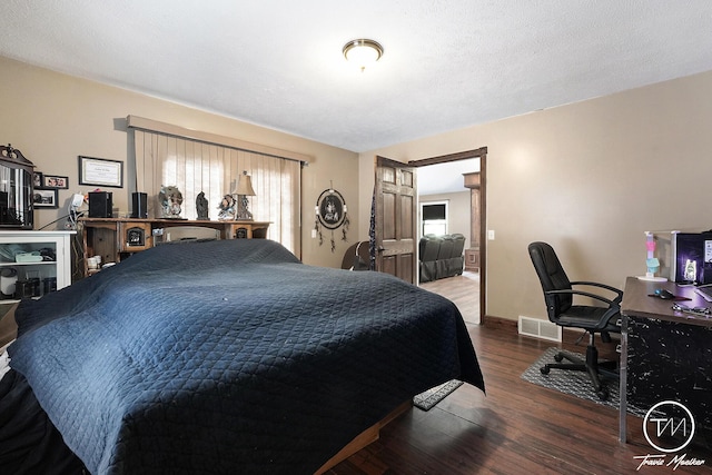 bedroom with wood-type flooring, a textured ceiling, and multiple windows