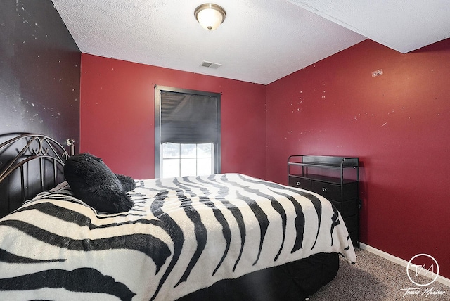 carpeted bedroom with a textured ceiling and vaulted ceiling