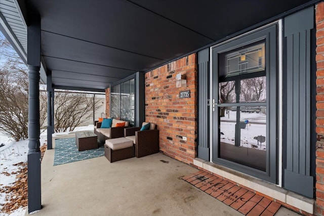 snow covered property entrance with covered porch