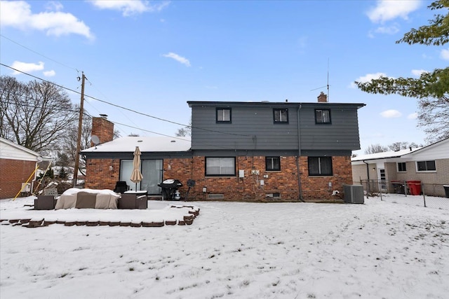 snow covered back of property with central air condition unit