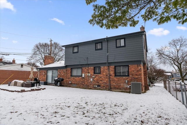 snow covered property with cooling unit