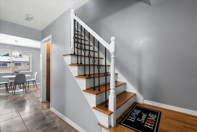 staircase featuring tile patterned floors and a chandelier