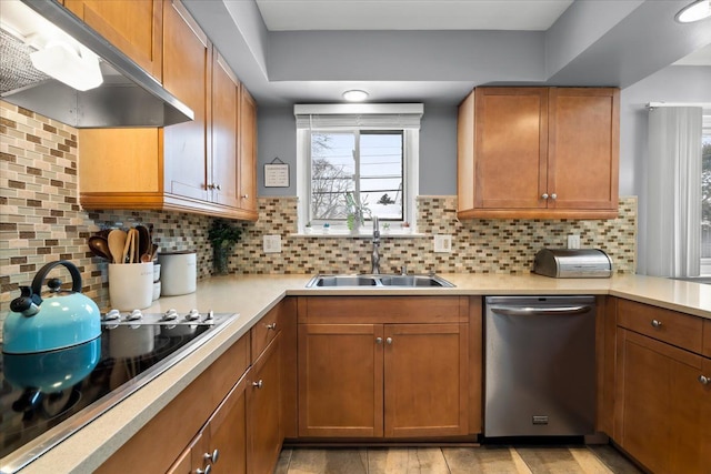 kitchen with sink, black electric stovetop, stainless steel dishwasher, and decorative backsplash