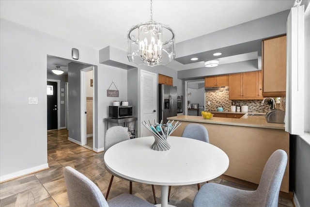 dining room with sink and a notable chandelier