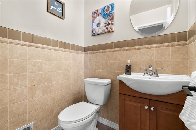 bathroom with tile walls, toilet, and vanity