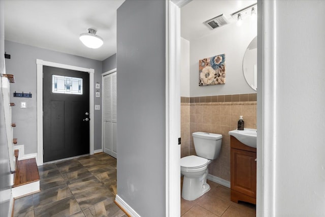 entryway with tile walls and sink