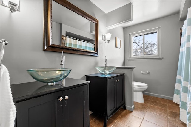 bathroom featuring toilet, vanity, and tile patterned flooring