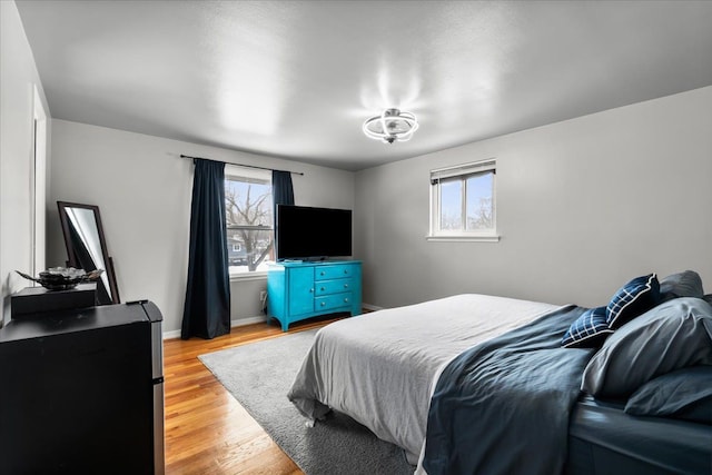 bedroom with light hardwood / wood-style floors and multiple windows