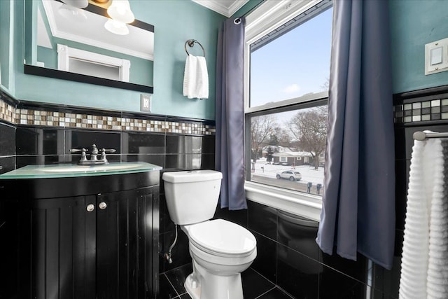 bathroom featuring toilet, ornamental molding, tile walls, and vanity