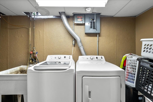 clothes washing area featuring electric panel and washing machine and clothes dryer