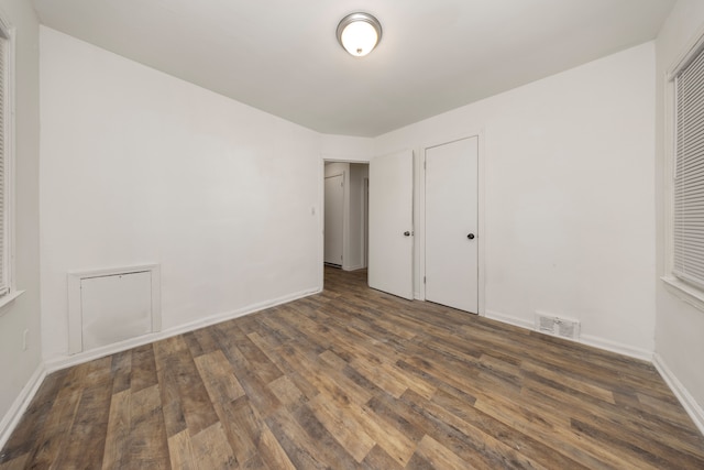 unfurnished bedroom with dark wood-type flooring