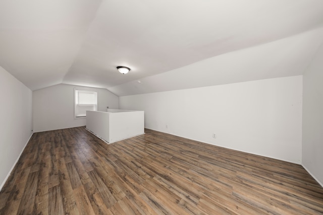 additional living space with dark hardwood / wood-style floors and vaulted ceiling