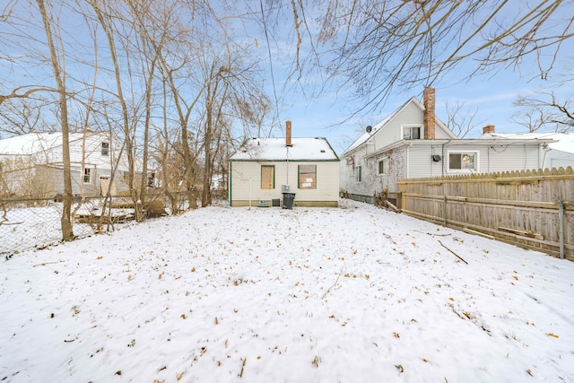 view of snow covered back of property