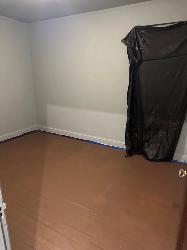 unfurnished room with baseboards and wood finished floors