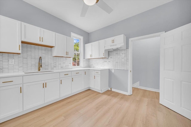 kitchen featuring decorative backsplash, ceiling fan, sink, light hardwood / wood-style flooring, and white cabinetry