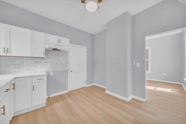 kitchen featuring decorative backsplash, light hardwood / wood-style floors, white cabinetry, and ceiling fan