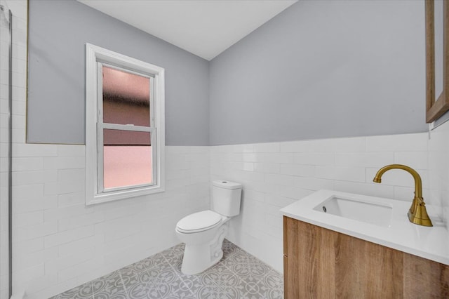 bathroom featuring tile patterned flooring, vanity, tile walls, and toilet