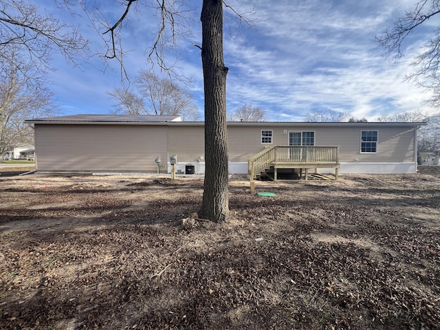 rear view of house with central AC unit and a wooden deck