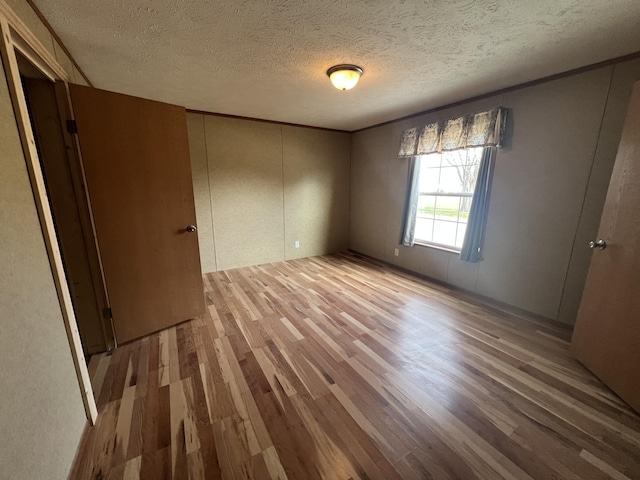 unfurnished bedroom featuring light hardwood / wood-style floors and a textured ceiling