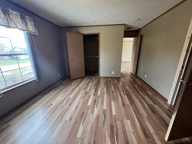 unfurnished bedroom with a textured ceiling, hardwood / wood-style flooring, and a closet