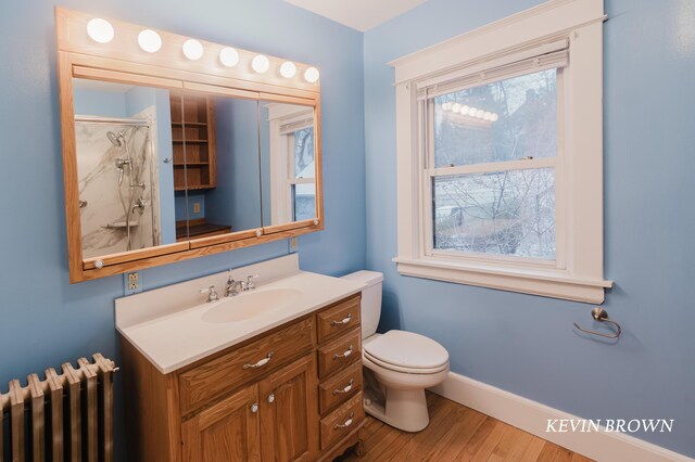 full bath featuring toilet, a shower with door, wood finished floors, radiator, and baseboards