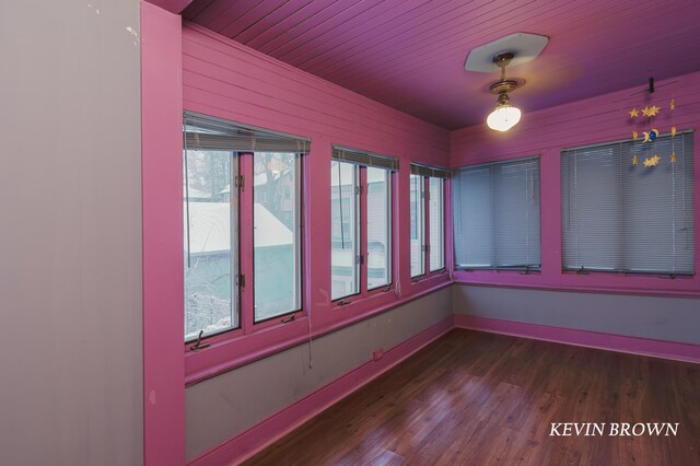 spare room featuring wooden ceiling, wood finished floors, and baseboards