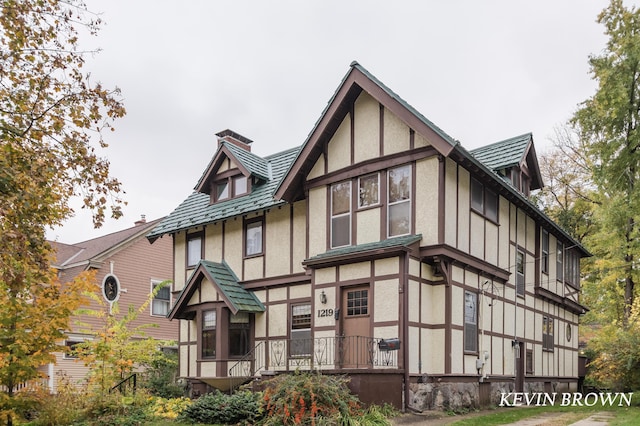 view of front facade featuring a chimney and stucco siding