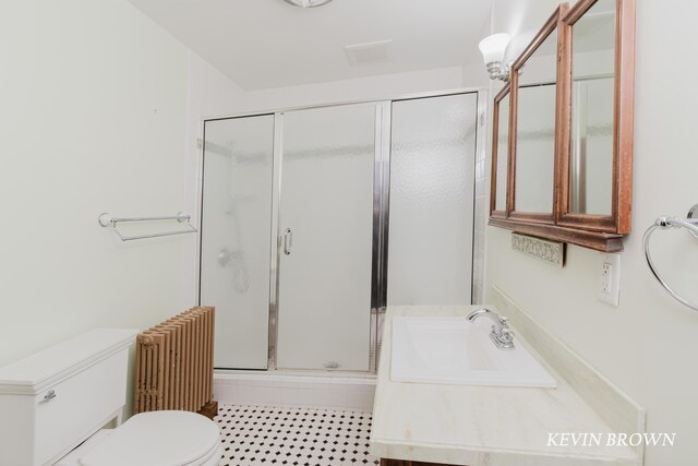 bathroom with vanity, radiator heating unit, a stall shower, tile patterned flooring, and toilet