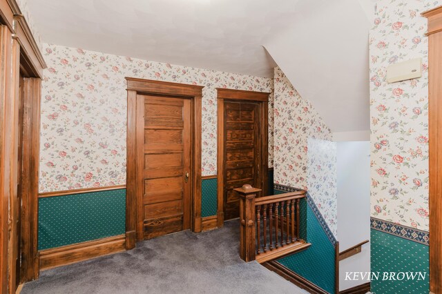 bedroom with wallpapered walls, a wainscoted wall, and carpet floors