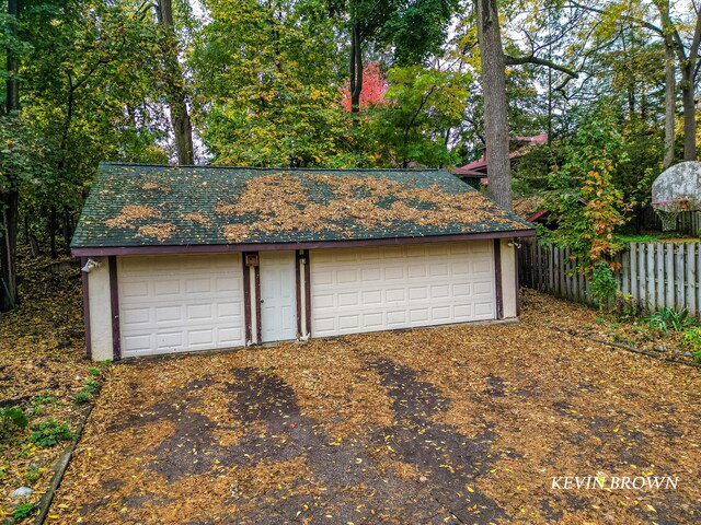 detached garage featuring fence