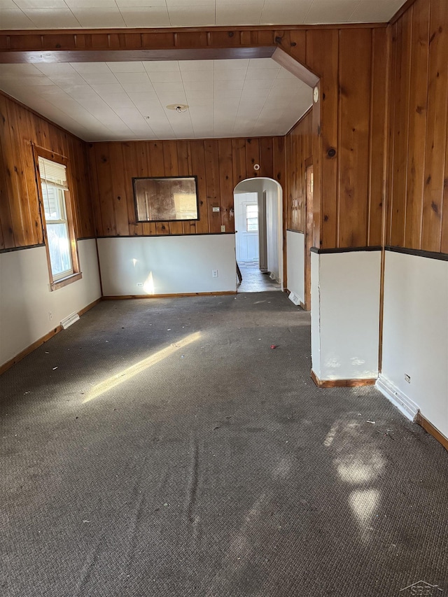 carpeted empty room with wooden walls