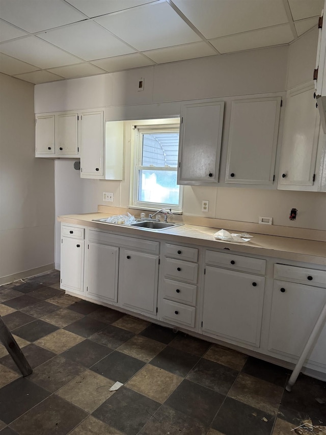 kitchen featuring white cabinets, a paneled ceiling, and sink