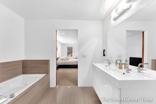 bathroom with a textured ceiling, vanity, tile patterned flooring, and a relaxing tiled tub