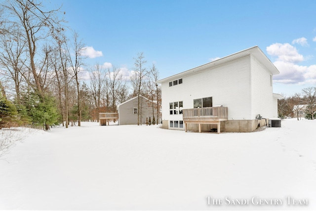 snow covered property with a wooden deck