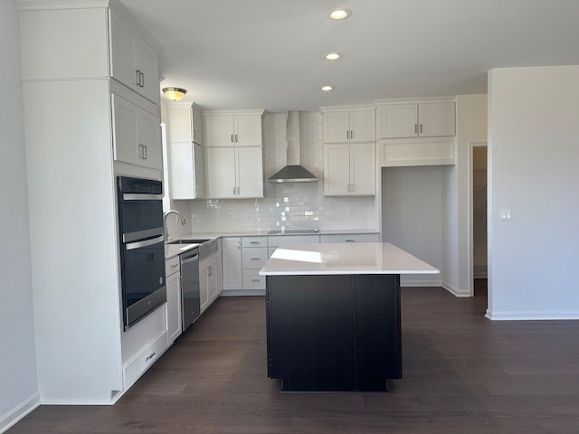 kitchen featuring appliances with stainless steel finishes, dark hardwood / wood-style flooring, wall chimney exhaust hood, and a kitchen island