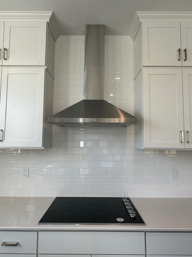 kitchen featuring tasteful backsplash, white cabinets, and wall chimney exhaust hood