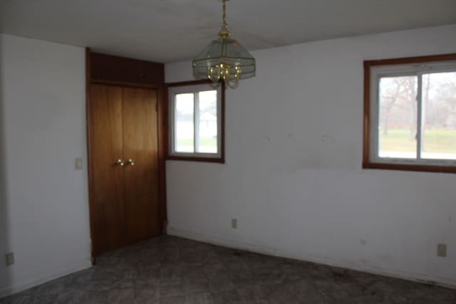 spare room featuring a wealth of natural light and a notable chandelier