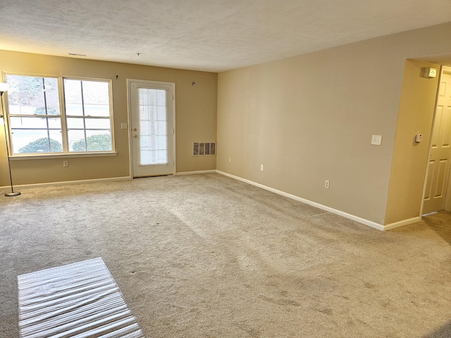 carpeted spare room with a textured ceiling