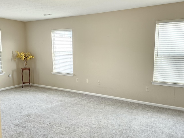 carpeted empty room with a textured ceiling