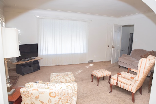 carpeted living room with ornamental molding