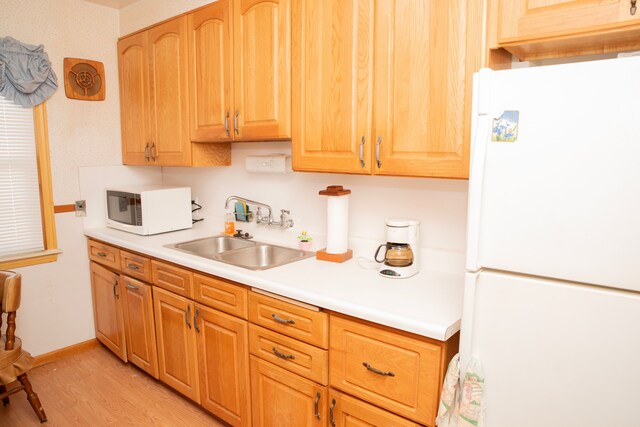 kitchen with white appliances, light hardwood / wood-style flooring, and sink